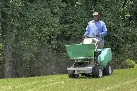 technician fertilizing lawn